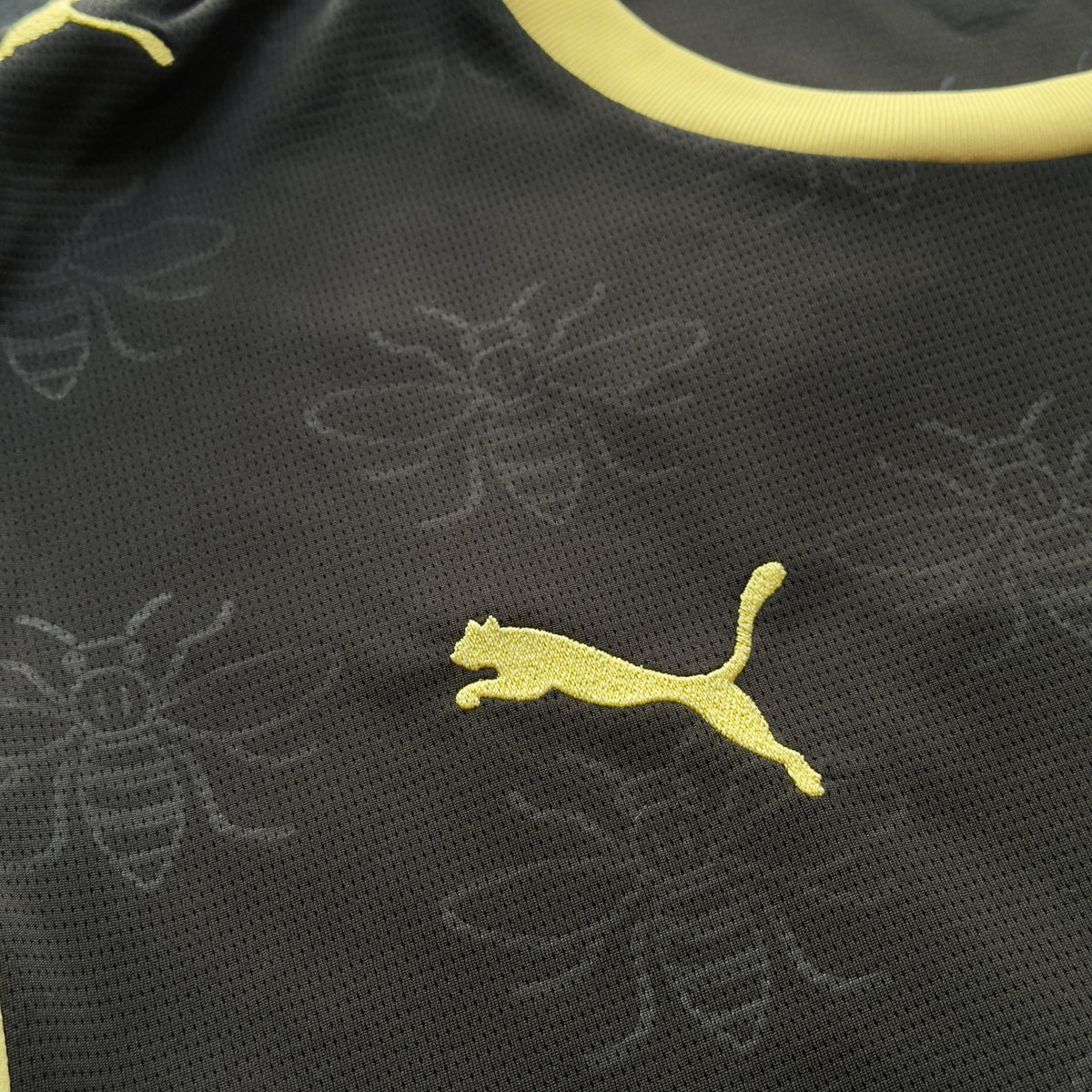 Yellow Puma logo and tonal Manchester bee pattern on the City away jersey