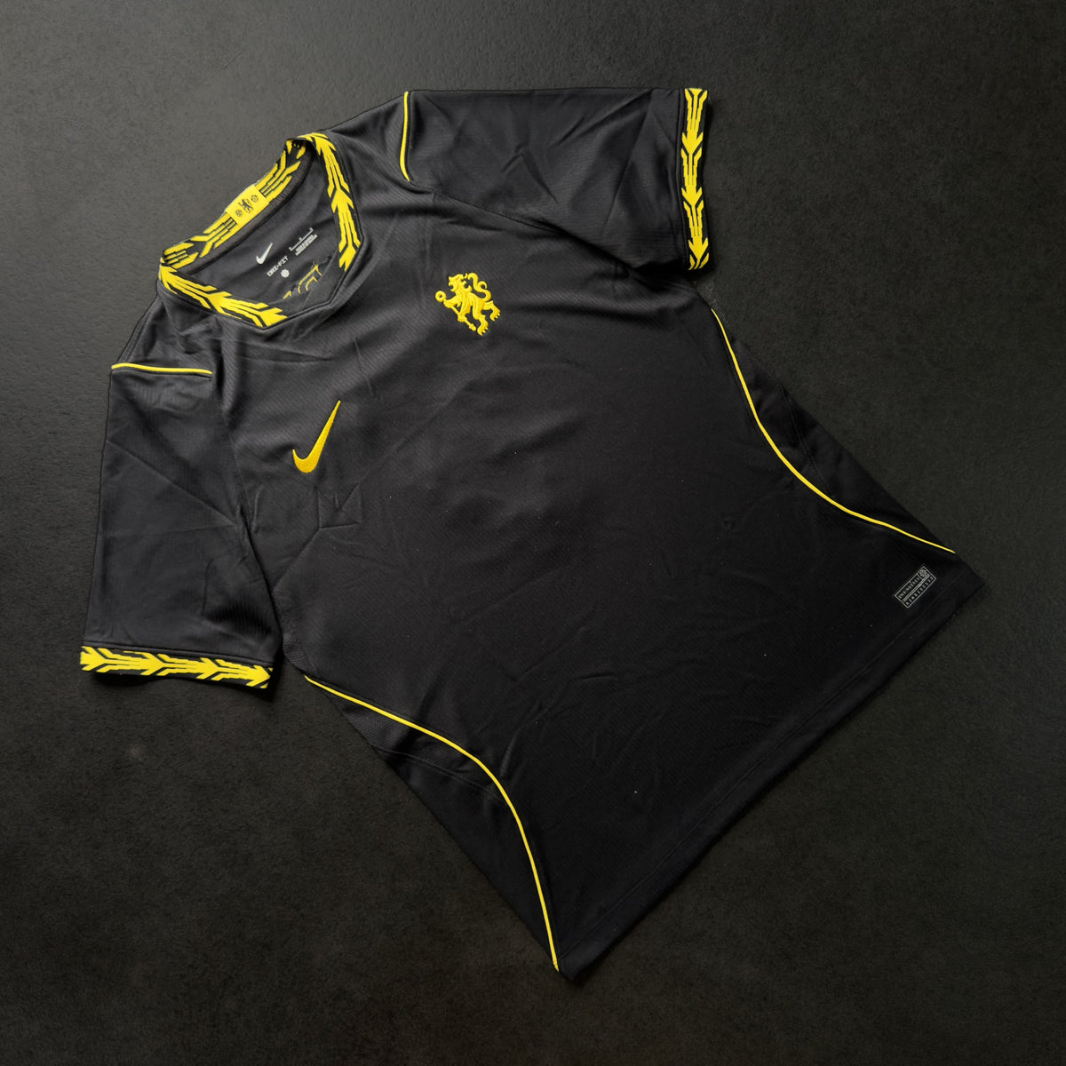 Front of the black Chelsea away jersey with yellow trim and Nike swoosh