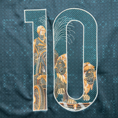 Close-up of the embroidered 10 on the away jersey: the Cibeles statue and chariot in the 1, the lions and the fountain's rising jet of water in the 0
