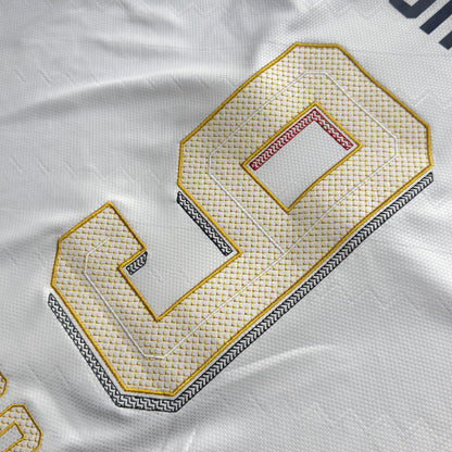 Close-up of Kane's 9 embroidered in white and gold with geometric fill stitching