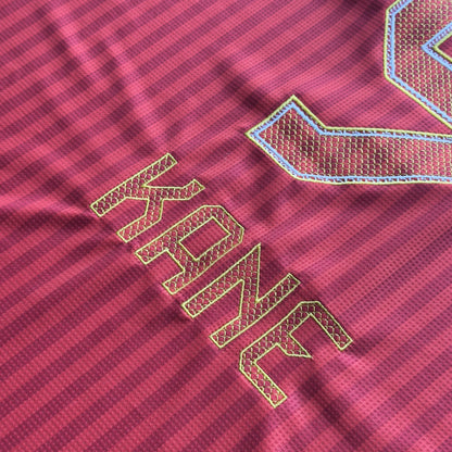 Close-up of the gold-outlined KANE nameset and 9 embroidery on the red Bayern home jersey
