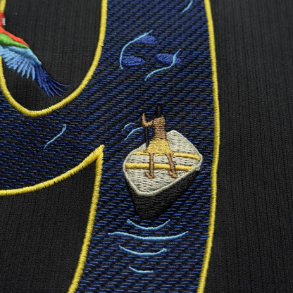 Close-up of an embroidered Amazon river boat on rippling water inside the 9