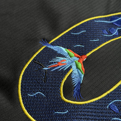 Close-up of a scarlet macaw stitched across the curve of the 9
