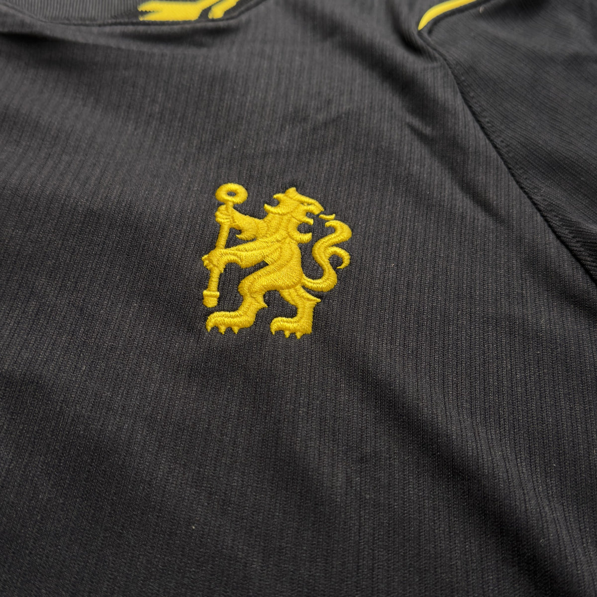 Yellow Chelsea lion crest on the front of the away jersey