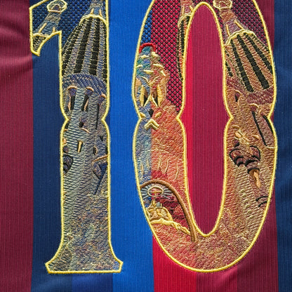 The full 10 head-on: every tower in gold-outlined stone, running across the blaugrana stripes