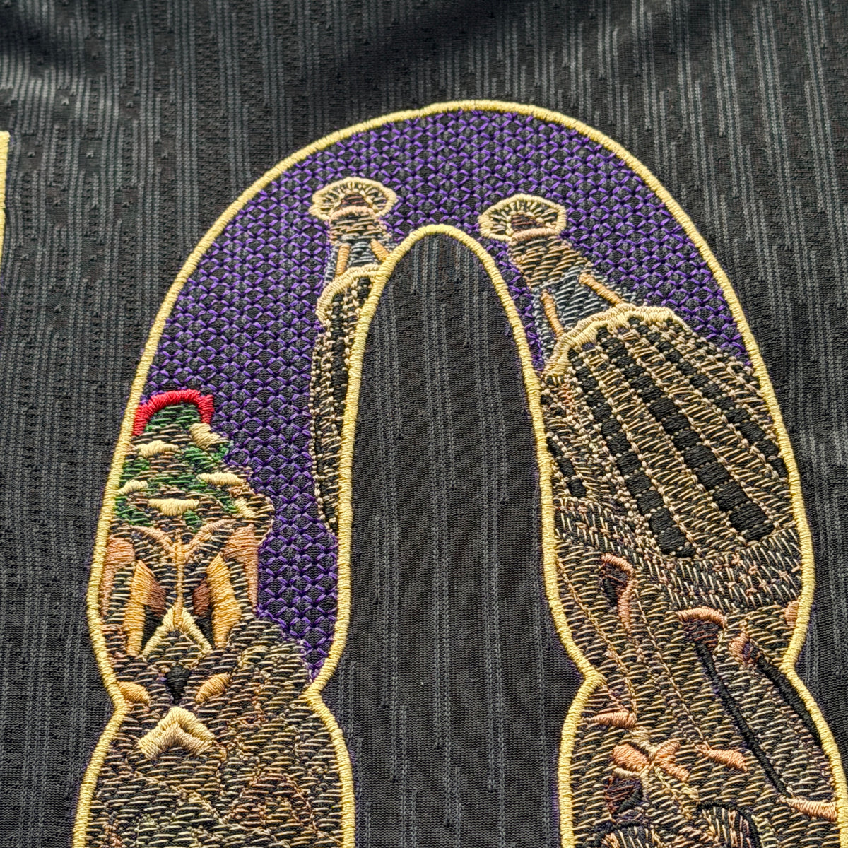 Top of the 0: two spire tops against the purple night sky, stitched as a mesh so the gold reads through