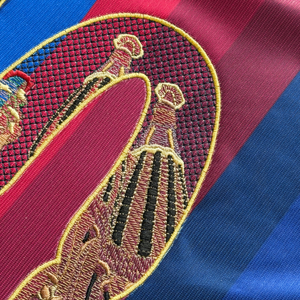 Top of the 0: spire tops outlined in gold thread, with the stone sitting directly on the blaugrana stripes